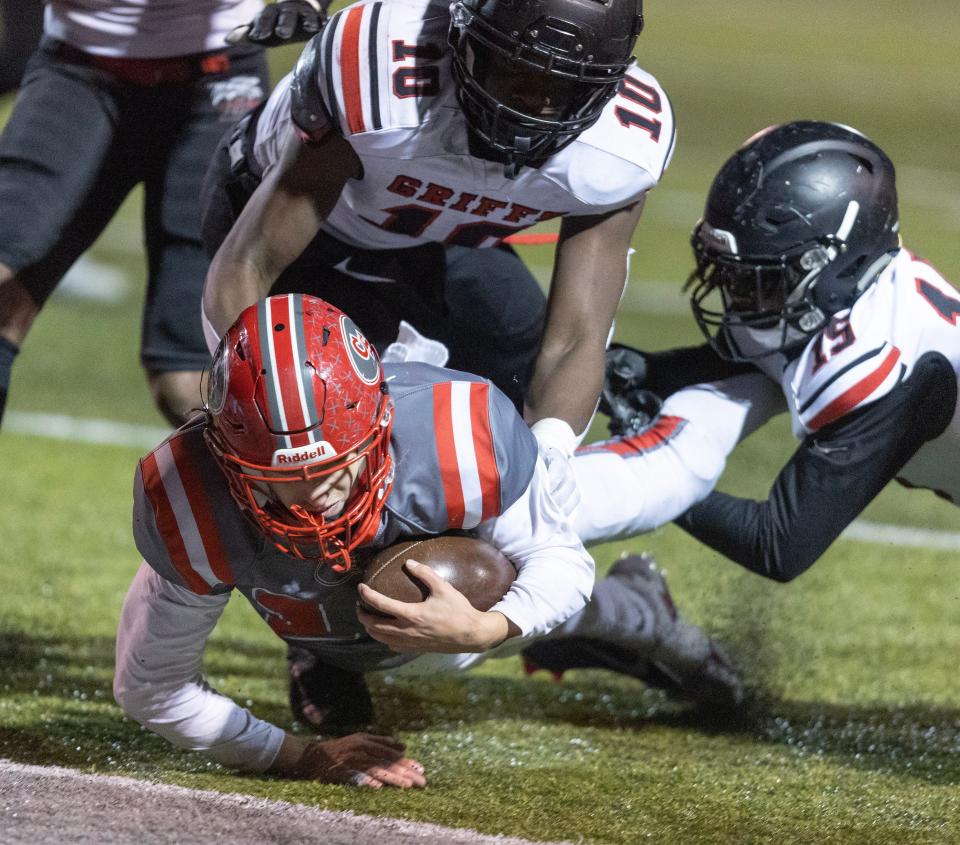 Canton South's Poochie Snyder dives in for a first-half touchdown defended by Buchtel's Demetrice Coates, left, and Arman Gable in a playoff game Friday, Nov. 3, 2023.