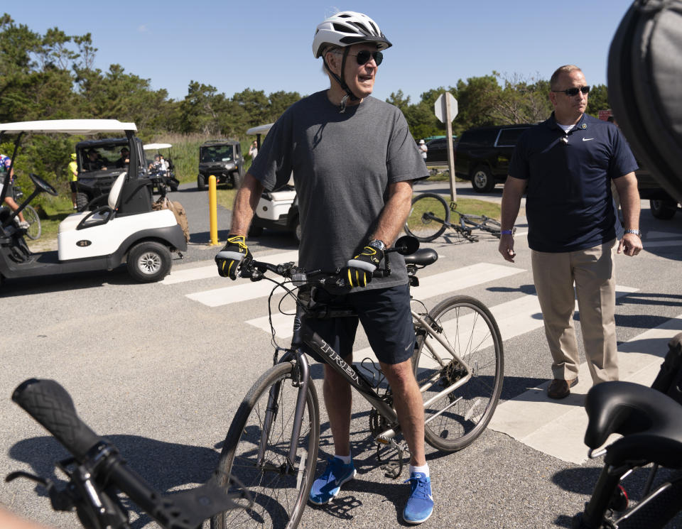 President Joe Biden gets back on his bike after he fell when he tried to get off his bike to greet a crowd at Gordons Pond in Rehoboth Beach, Del., Saturday, June 18, 2022. (AP Photo/Manuel Balce Ceneta)