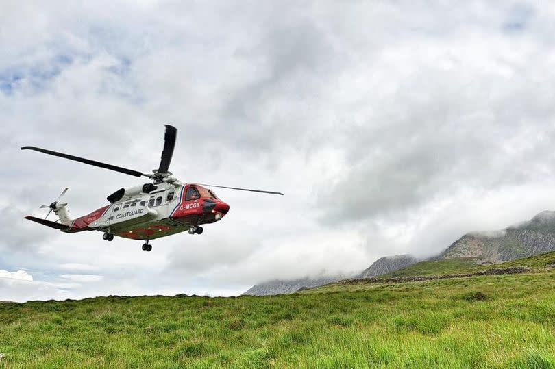 A helicopter landing on Cadair Idris in Eryri