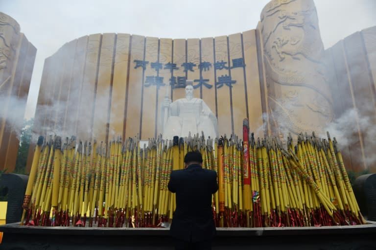 A man makes an offering in front of a statue of the Yellow Emperor, or Huangdi, after a memorial ceremony in Xinzheng, in China's Henan province