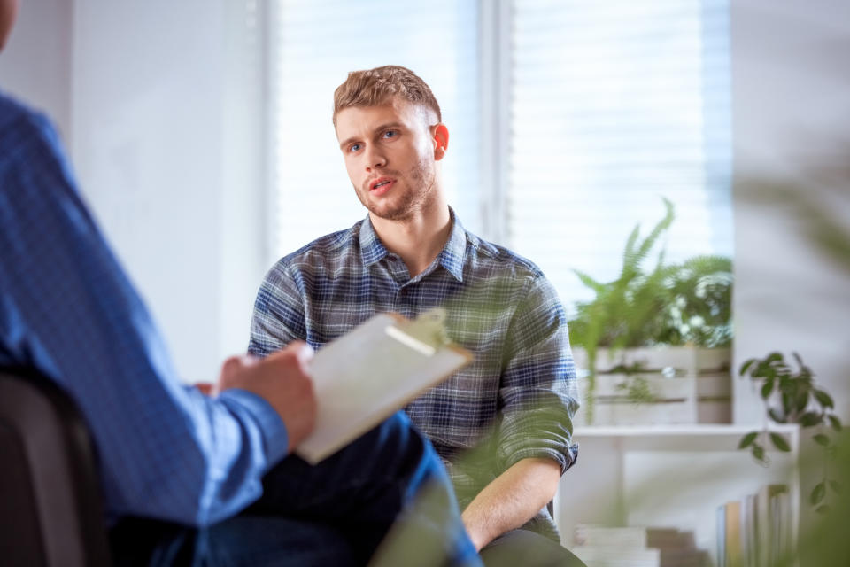 A man sitting and looking thoughtful opposite someone else