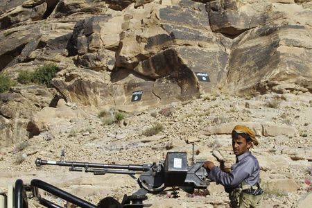 A Shi'ite Houthi mans a weapon on the back of a patrol truck, as Ansar al-Sharia flags are seen in the background, along a road in Almnash, the main stronghold of Ansar al-Sharia, in Rada November 22, 2014. REUTERS/Mohamed al-Sayaghi