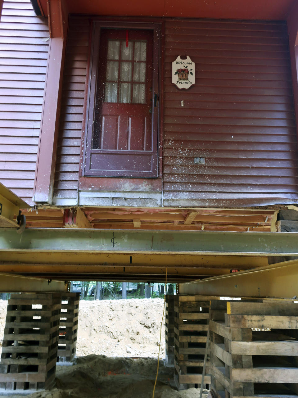 In this July 1, 2019 photo, Peter Brenn's home in Willington, Conn., sits elevated so the concrete foundation can be replaced. The foundation had been deteriorating due to the presence of an iron sulfide known as pyrrhotite, often described as "a slow-moving disaster," which causes concrete to crack and break gradually as it becomes exposed to water and oxygen. After worrying for years about the foundations crumbling beneath their houses, hundreds of suburban homeowners in a large swath of eastern Connecticut are getting help from the state to salvage their properties that had been doomed by bad batches of concrete. (AP Photo/Ted Shaffrey)