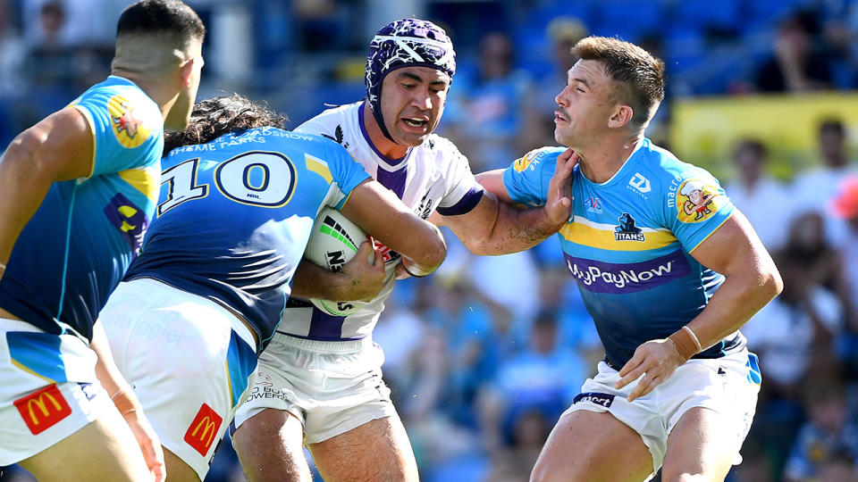 Jahrome Hughes attempts to bust through a Gold Coast Titans tackle.