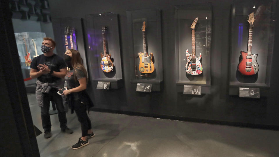 Two people look at an exhibit at the Rock and Roll Hall of Fame, Monday, June 15, 2020, in Cleveland. The Rock & Roll Hall of Fame reopened to the public on Monday with new health and safety precautions in place to protect staff and guests. (AP Photo/Tony Dejak)