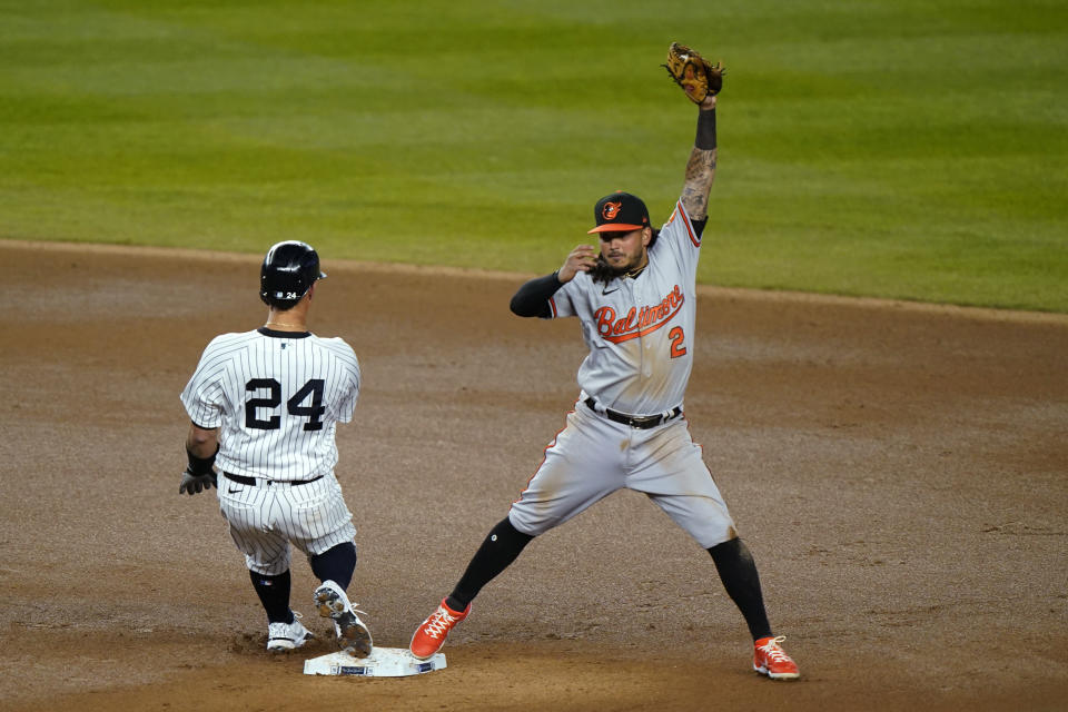 Baltimore Orioles shortstop Freddy Galvis (2) reaches for the throw from the outfield as New York Yankees' Gary Sanchez pulls into second with a double during the sixth inning of a baseball game Wednesday, April 7, 2021, at Yankee Stadium in New York. (AP Photo/Kathy Willens)