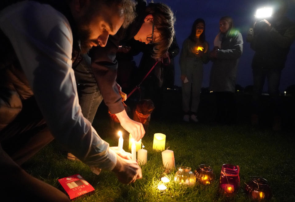 People light candles at a vigil in Leigh-on-Sea, Essex, England, Saturday, Oct. 16, 2021 to honor British Conservative lawmaker David Amess who died after being stabbed at a constituency surgery on Friday. Leaders from across the political spectrum came together Saturday to pay their respects to Amess who was stabbed to death in what police say was a terrorist-related attack. (AP Photo/Alberto Pezzali)