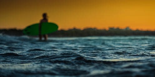 <span class="caption">Surfing has a range of health benefits. </span> <span class="attribution"><a class="link " href="https://www.shutterstock.com/image-photo/unrecognizable-surfer-waling-into-ocean-focul-2274501199" rel="nofollow noopener" target="_blank" data-ylk="slk:BART SADOWSKI PL/Shutterstock;elm:context_link;itc:0;sec:content-canvas">BART SADOWSKI PL/Shutterstock</a></span>