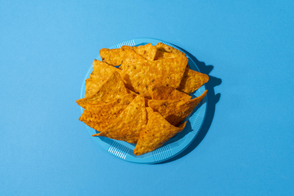 Directly Above View Of Nachos On A Blue Colored Plastic Plate On a Blue Background