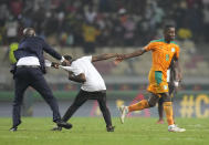Ivory Coast's Max Gradel, right, is pulled by a fan who invaded the playing field at the end of the African Cup of Nations 2022 group E soccer match between Ivory Coast and Algeria at the Japoma Stadium in Douala, Cameroon, Thursday, Jan. 20, 2022. (AP Photo/Themba Hadebe)