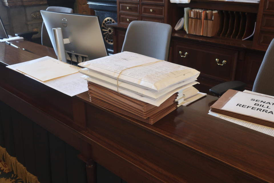 Kansas House bills, including the House's version of the next proposed state budget in the big brown folders, sit at the work station of the secretary of the state Senate and his staff at the Statehouse in Topeka, Kan., Thursday, March 21, 2024. The House is now listing the names of groups and lobbyists that are seeking legislation on the bills and resolutions that members and committees introduce. (AP Photo/John Hanna)