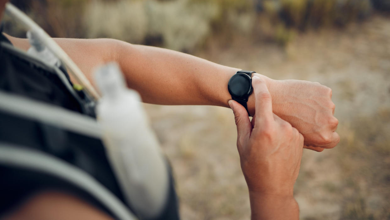  Man using sports watch during trail run 