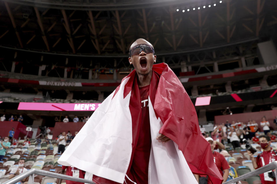 Gold medalist Mutaz Barshim of Qatar celebrates on the track after winning the final of the men's high jump at the 2020 Summer Olympics, Sunday, Aug. 1, 2021, in Tokyo, Japan. (Cameron Spencer/Pool Photo via AP)