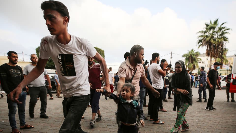 People gather as medics transport injured people into Al-Aqsa Martyrs Hospital in Deir al-Balah in Gaza, following an Israeli strike on October 22. - Majdi Fathi/NURPHO/AP