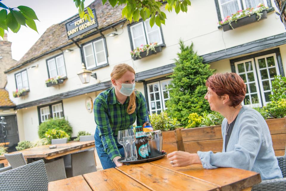 Greene King staff in PPE at the Fort St George pub in Cambridge (PA Media)