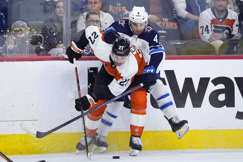 Philadelphia Flyers' Noah Cates, left, collides with Winnipeg Jets' Neal Pionk during the first period of an NHL hockey game, Thursday, Feb. 8, 2024, in Philadelphia. (AP Photo/Matt Slocum)