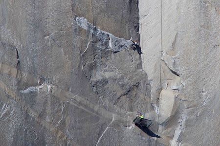 Climber Kevin Jorgeson (shirtless) climbs Pitch 17 as his partner Tommy Caldwell belays from below on the Dawn Wall of the El Capitan rock formation in Yosemite National Park California in this January 12, 2015 handout photo released to Reuters January 13, 2015. REUTERS/Tom Evans/Elcapreport.com
