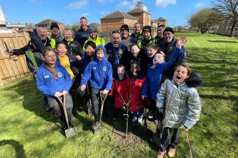 Bernicia estates team and 0800 Repair team with Dame Dorothy School children planting fruit trees in their secret garden