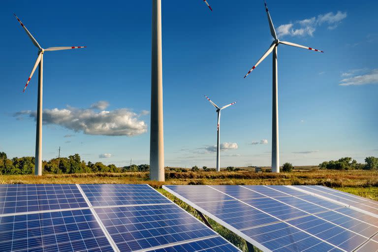 Wind turbines and solar panels closeup on sky background