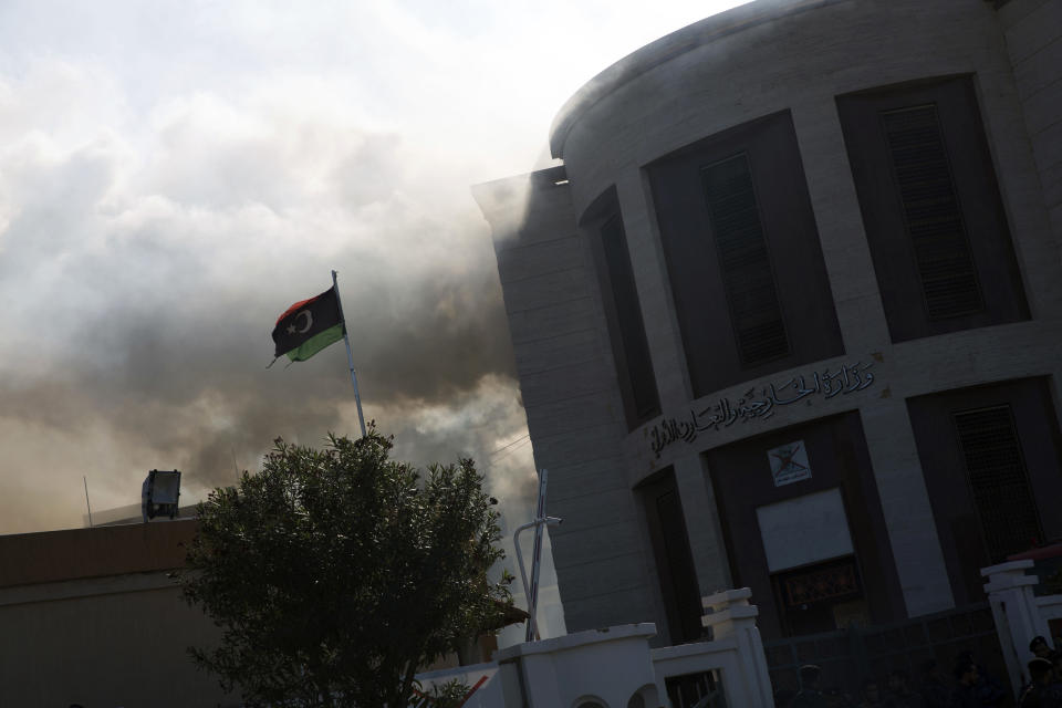 Smoke rises shortly after an attack on the foreign ministry building, in Tripoli, Libya, Tuesday, Dec, 25, 2018. Security officials said Tuesday that a suicide bomber targeted the entrance of Libya’s Foreign Ministry in Tripoli, killing several people, including a prominent militia leader. They said a second attacker was shot dead by guards before he could detonate his explosive vest. (AP Photo/Mohamed Ben Khalifa)