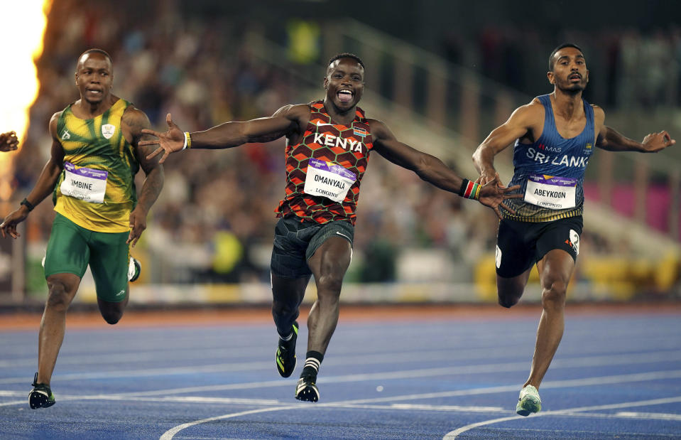 Kenya's Ferdinand Omanyala celebrates as he wins gold in the men's 100m final, in the Alexander Stadium at the Commonwealth Games in Birmingham, England, Wednesday, Aug. 3, 2022. At right is Sri Lanka's Yupun Abeykoon, 3rd and at left, South Africa's Akani Simbine who won silver. (Mike Egerton/PA via AP)