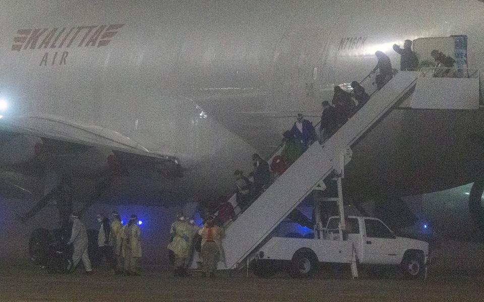 American passengers evacuated from a cruise ship in Japan disembark from a Kalitta Air flight at Kelly Field in Texas - AP