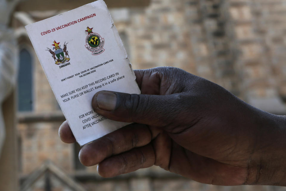 A government worker shows his vaccination card in Harare, Zimbabwe on Sunday, Sept, 19, 2021. Many employers in Zimbabwe are mandating COVID-19 vaccines for their staff, and the government has its own requirement that its 500,000 employees get the shots. (AP Photo/Tsvangirayi Mukwazhi)