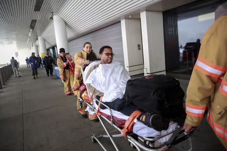 A passenger is wheeled on a stretcher by emergency medical services workers at LaGuardia Airport's Terminal D in New York March 5, 2015. REUTERS/Shannon Stapleton