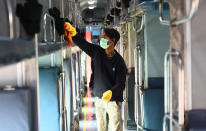 Workers wash and disinfect trains coaches at a rail yard, as a measure to prevent the spread of coronavirus in New Delhi