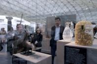 Visitors examine Islamic art works on September 17, 2012 in Paris, during a press visit of the new Department of Islamic Arts at the Louvre, the largest of its kind in Europe, with 3,000 artefacts on display, gathered from Spain to India and dating back to the seventh century AD. Intended to celebrate "The Radiant Face of a Great Civilization" the 100-million-euro project - largely financed by donors from across the Islamic world - will be inaugurated by French President ahead of its official opening on September 18. AFP PHOTO / KENZO TRIBOUILLARD