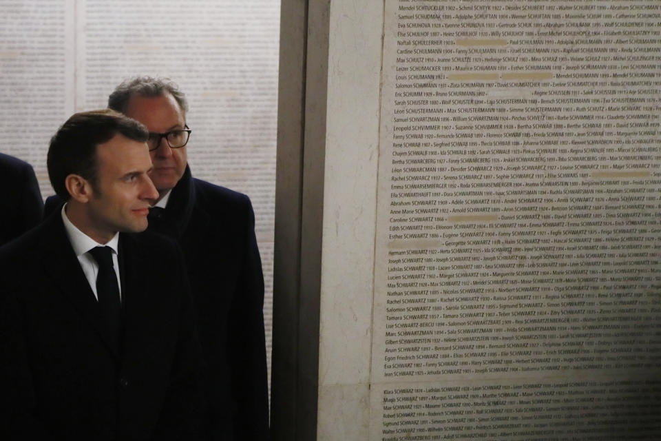 French President Emmanuel Macron, left, and French National Assembly house-speaker Richard Ferrand visit the Shoah memorial, Tuesday, Feb.19, 2019 in Paris. French residents and public officials from across the political spectrum geared up Tuesday for nationwide rallies against anti-Semitism following a series of anti-Semitic acts, including the swastikas painted on about 80 gravestones at a Jewish cemetery overnight. (AP Photo/Francois Mori, Pool)