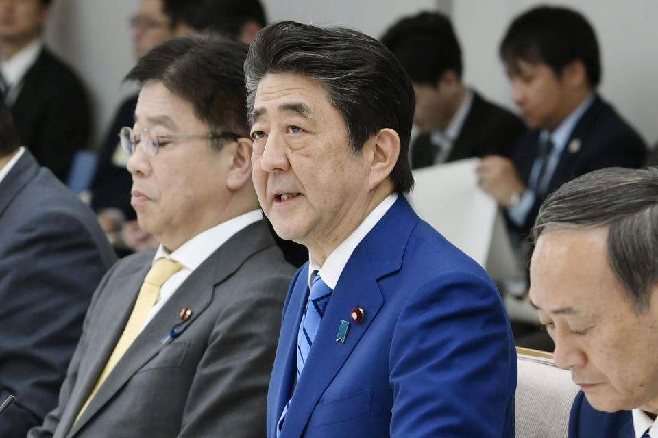 Japan's Prime Minister Shinzo Abe, center, speaks during a meeting of a task force on the new coronavirus at his official residence in Tokyo Thursday, Feb. 27, 2020. Abe was asking all elementary, middle and high schools to remain shut until spring holidays begin in late March. (Kyodo News via AP)