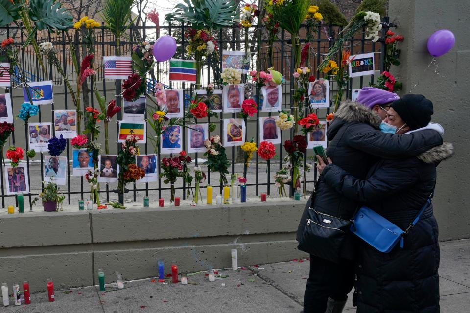 People hug after viewing a memorial for the victims of an apartment building fire near the site of the fire in the Bronx borough of New York, Thursday, Jan. 13, 2022.  Many of the victims of New York City’s deadliest fire in years are still awaiting burial after funerals began with services for two children killed by Sunday’s blaze in a Bronx apartment building.