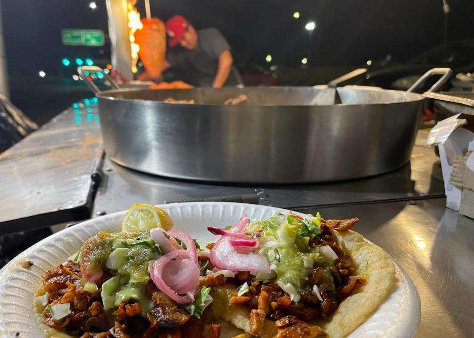 A taquero cooks marinated pork cooked on a trompo, or rotating vertical spit, for al pastor tacos topped with pineapple and served in handmade corn tortillas at Taquería Santo Domingo, on Chestnut Avenue near Martin Ray Reilly Park in Fresno on August 14, 2023.