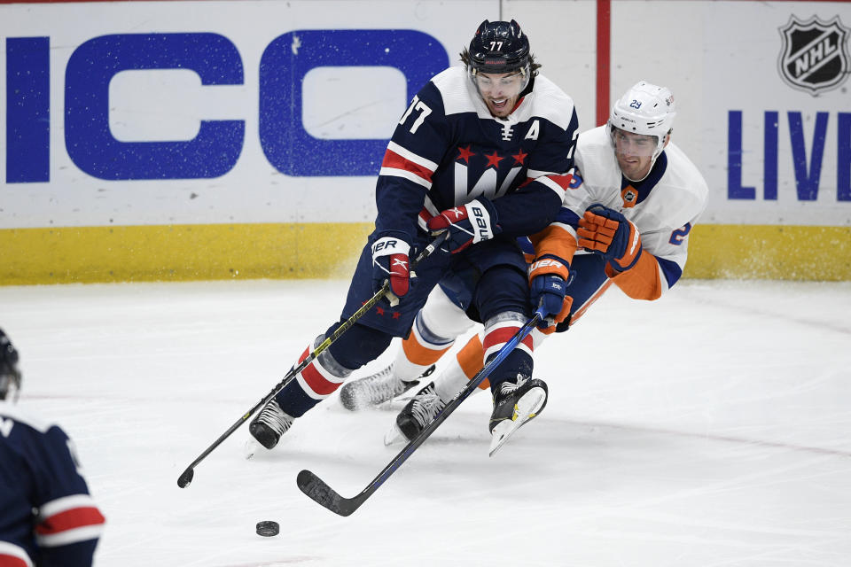 Washington Capitals right wing T.J. Oshie (77) and New York Islanders center Brock Nelson (29) vie for the puck during the second period of an NHL hockey game Tuesday, Jan. 26, 2021, in Washington. (AP Photo/Nick Wass)