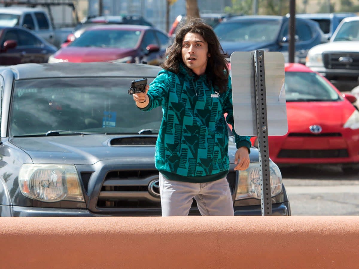 A man who identified himself to the Albuquerque Journal as Ryan Martinez, of East Mountains, pulls a gun during a rally (AP)