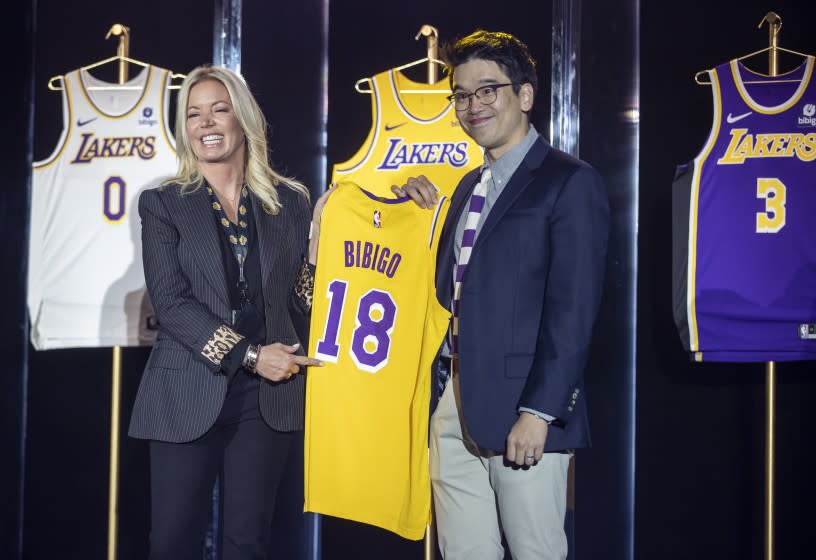 EL SEGUNDO, CA - September 20: Jeanie Buss, CEO / Governor / Co-owner of the Los Angeles Lakers, left, and Sun-Ho Lee, Bibigo Head of Global Business Planning, hold a jersey featuring the Bibigo logo, as the Lakers host a 2021-2022 season kick-off event to unveil and announce a new global marketing partnership with Bibigo, which will appear on the Lakers' jersey at the UCLA Health Training Center in El Segundo on Monday, Sept. 20, 2021. (Allen J. Schaben / Los Angeles Times)