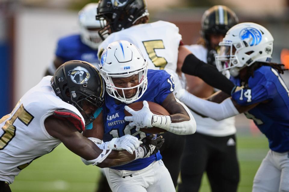 Fayetteville's Braxton Knotts gets hit by Pembroke's LaTrell Jewsome during the first quarter on Saturday, Sept. 3, 2022, at Fayetteville State University.