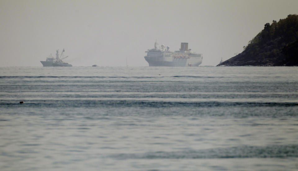 The Costa Allegra Cruise ship, right, is towed in the Victoria's harbor, Seychelles Island, Thursday, March 1, 2012. The disabled cruise ship is arriving in port in the island nation of the Seychelles after three days at sea without power. The Costa Allegra has been at sea with more than 1,000 people onboard and without electricity since a fire in the generator room on Monday. (AP Photo/Gregorio Borgia)