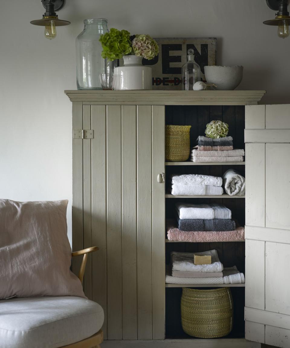 Open cabinet containing folded towels