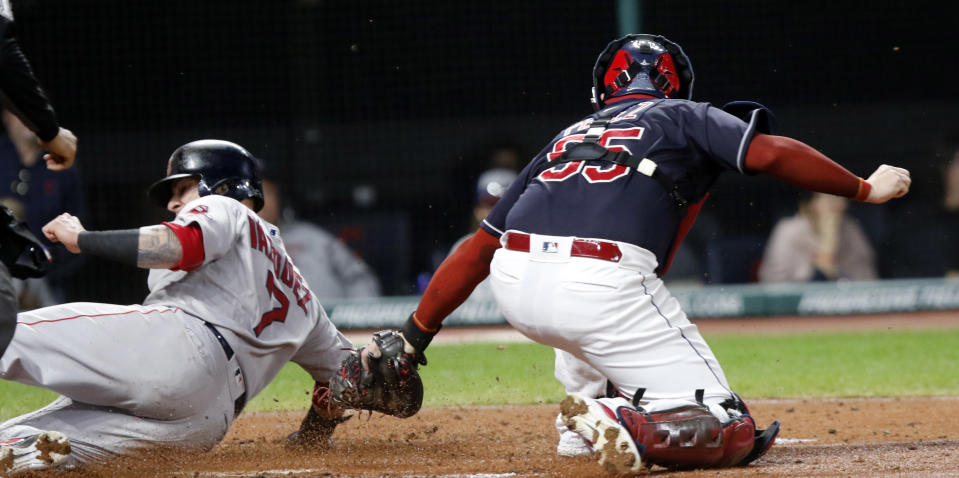 Boston Red Sox's Christian Vazquez, left, slides past the tag by Cleveland Indians catcher Roberto Perez, right, scoring on a ground-out by Rafael Devers in the third inning of a baseball game, Sunday, Sept. 23, 2018, in Cleveland. (AP Photo/Tom E. Puskar)