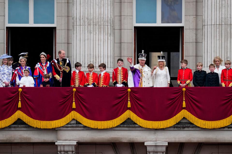 A wide view of the coronation party flanking King Charles III and Queen Camilla on the balcony of Buckingham Palace.