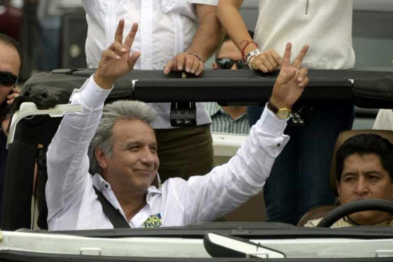 Ecuadorean presidential candidate for the Alianza Pais party Lenin Moreno (L) waves to supporters during a motorcade in Guayaquil, Ecuador on February 22, 2017