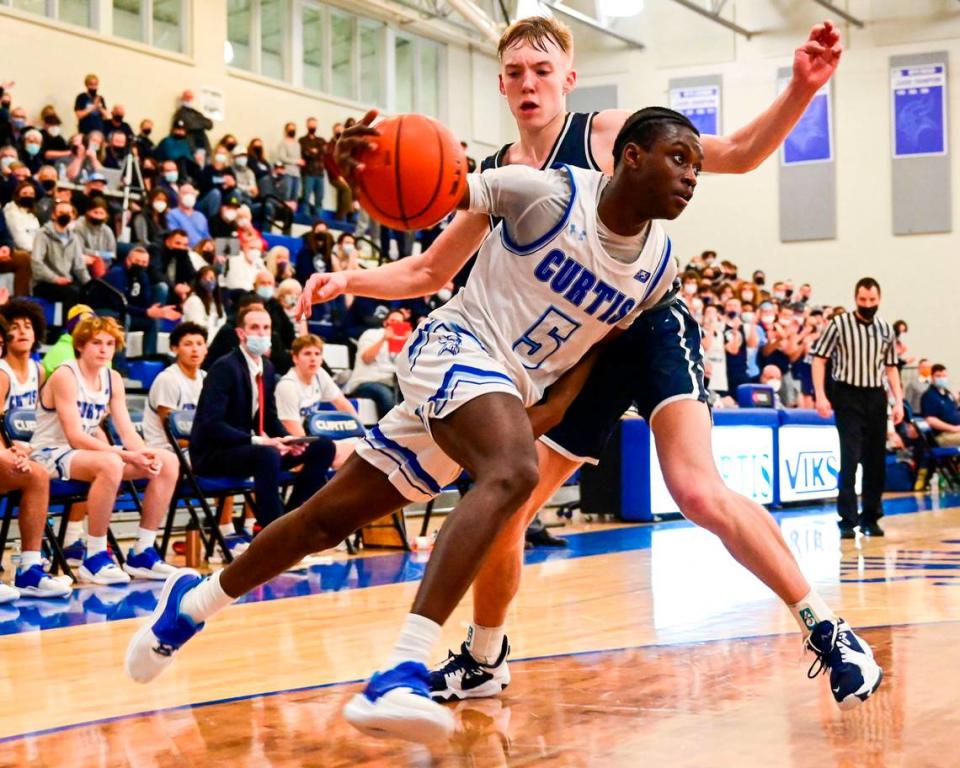 Curtis guard Zoom Diallo (5) drives to the basket as Olympia guard Parker Gerrits (22) defends during the fourth quarter of a 4A South Puget Sound League game on Friday, Jan. 21, 2022, at Curtis High School in University Place, Wash.