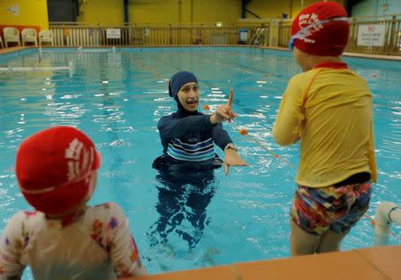 Australian muslim swimming instructor Fadila Chafic wears her full-length 'burkini' swimsuit during a swimming lesson with her children Taaleen (L) and Ibrahim at swimming pool in Sydney, August 23, 2016. REUTERS/Jason Reed