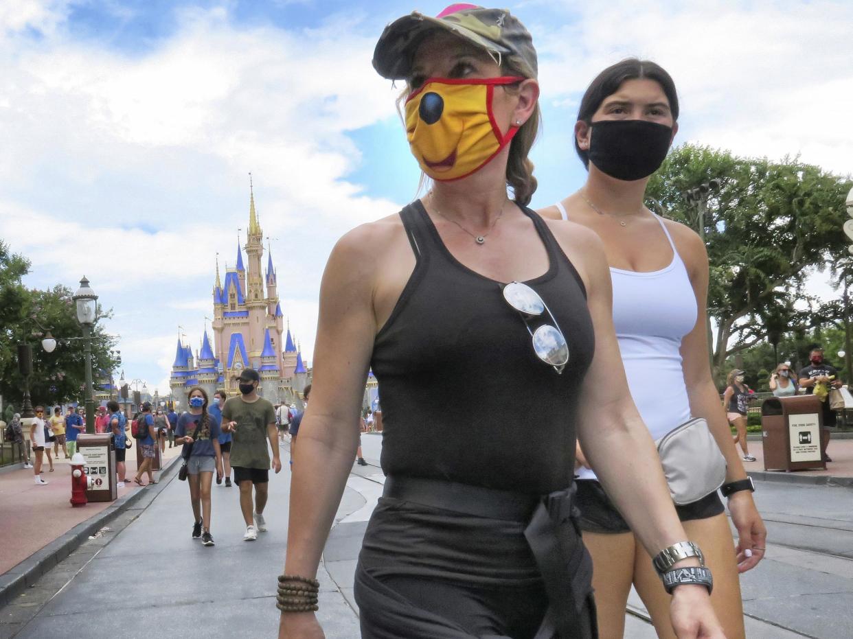 Guests wear masks as required to attend the official reopening day of the Magic Kingdom at Walt Disney World in Lake Buena Vista, Florida: AP