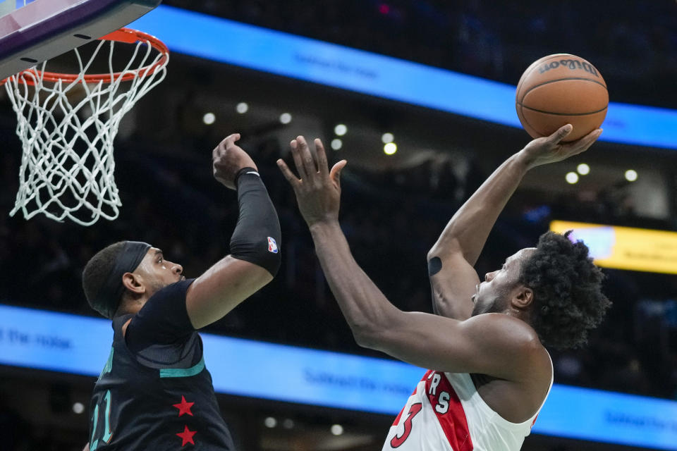 Toronto Raptors forward O.G. Anunoby, right, shoots over Washington Wizards center Daniel Gafford during the first half of an NBA basketball game Wednesday, Dec. 27, 2023, in Washington. (AP Photo/Alex Brandon)