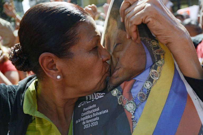 A woman kisses a portrait of Venezuelan leader Hugo Chavez during a rally outside the Miraflores Palace in Caracas, on January 10, 2013. Fighter jets streaked the sky as allies from around the region, showered praise on the cancer-stricken leader one after another and pledged their undying support