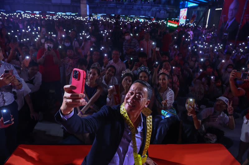 Srettha Thavisin, a local property tycoon and Pheu Thai Party's prime ministerial candidate, takes a selfie with supporters during a campaign event for the upcoming general election in Bangkok