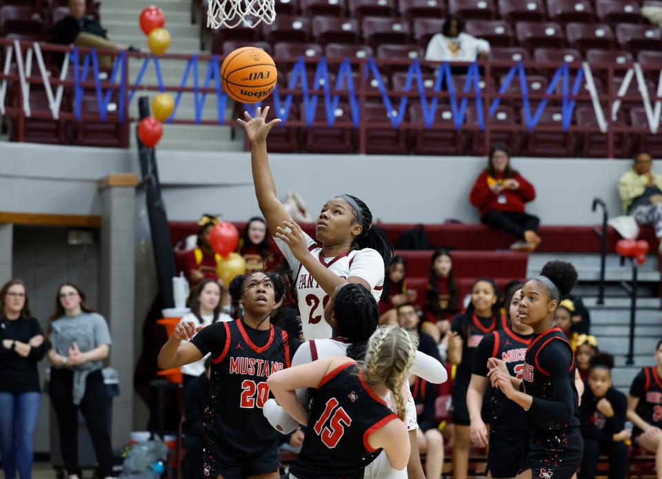 Putnam City North's Demy Howard (20) shoots between Mustang defenders during a girls game between Mustang and Putnam City North at Putnam CIty North HS in Oklahoma City.